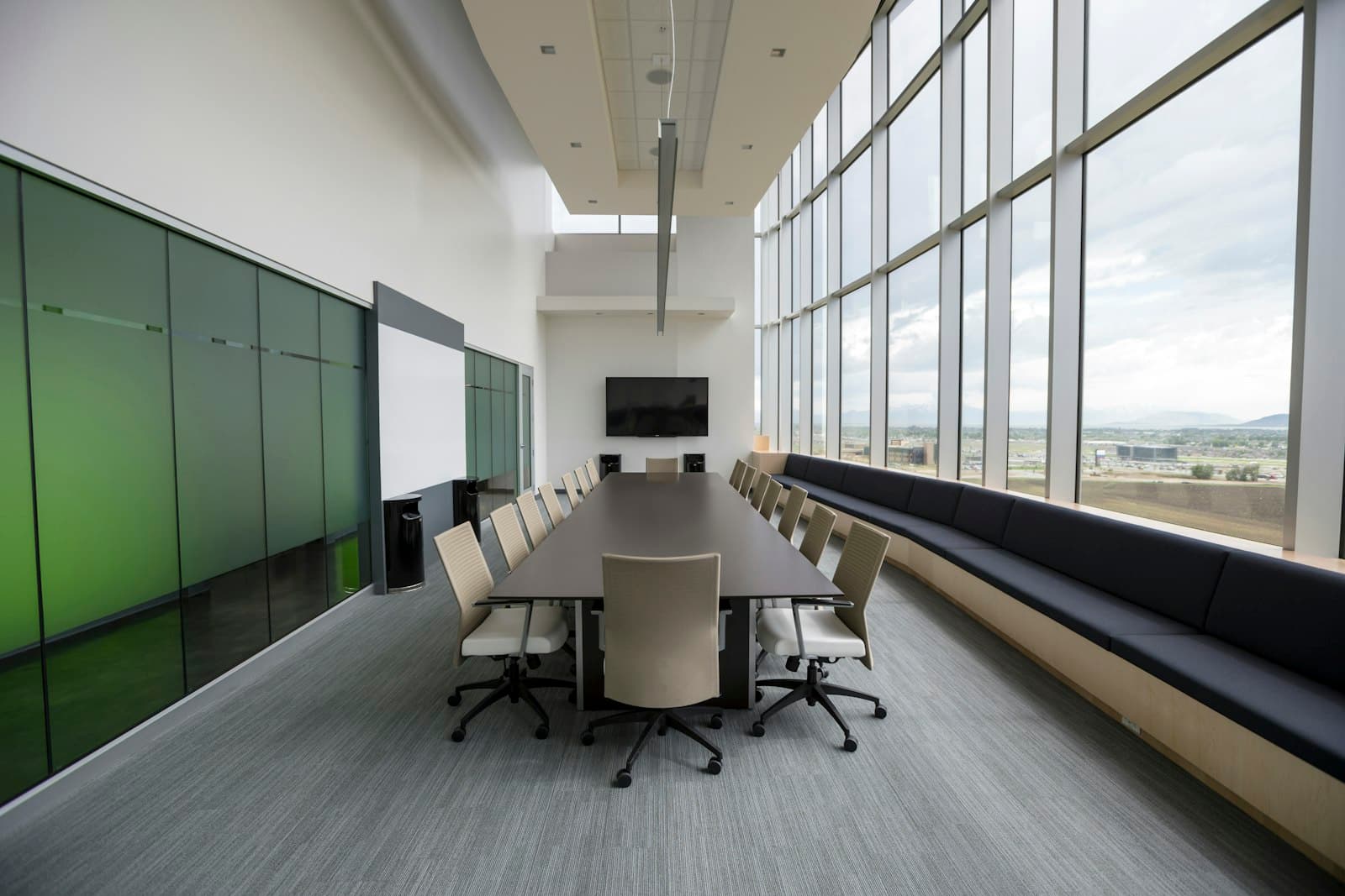 Empty modern boardroom with a long table and floor-to-ceiling windows