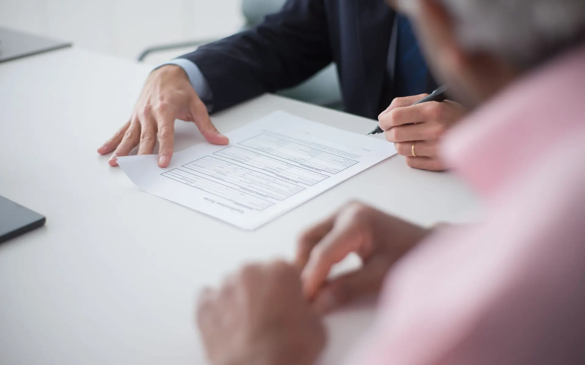 Two people reviewing a document before signing.